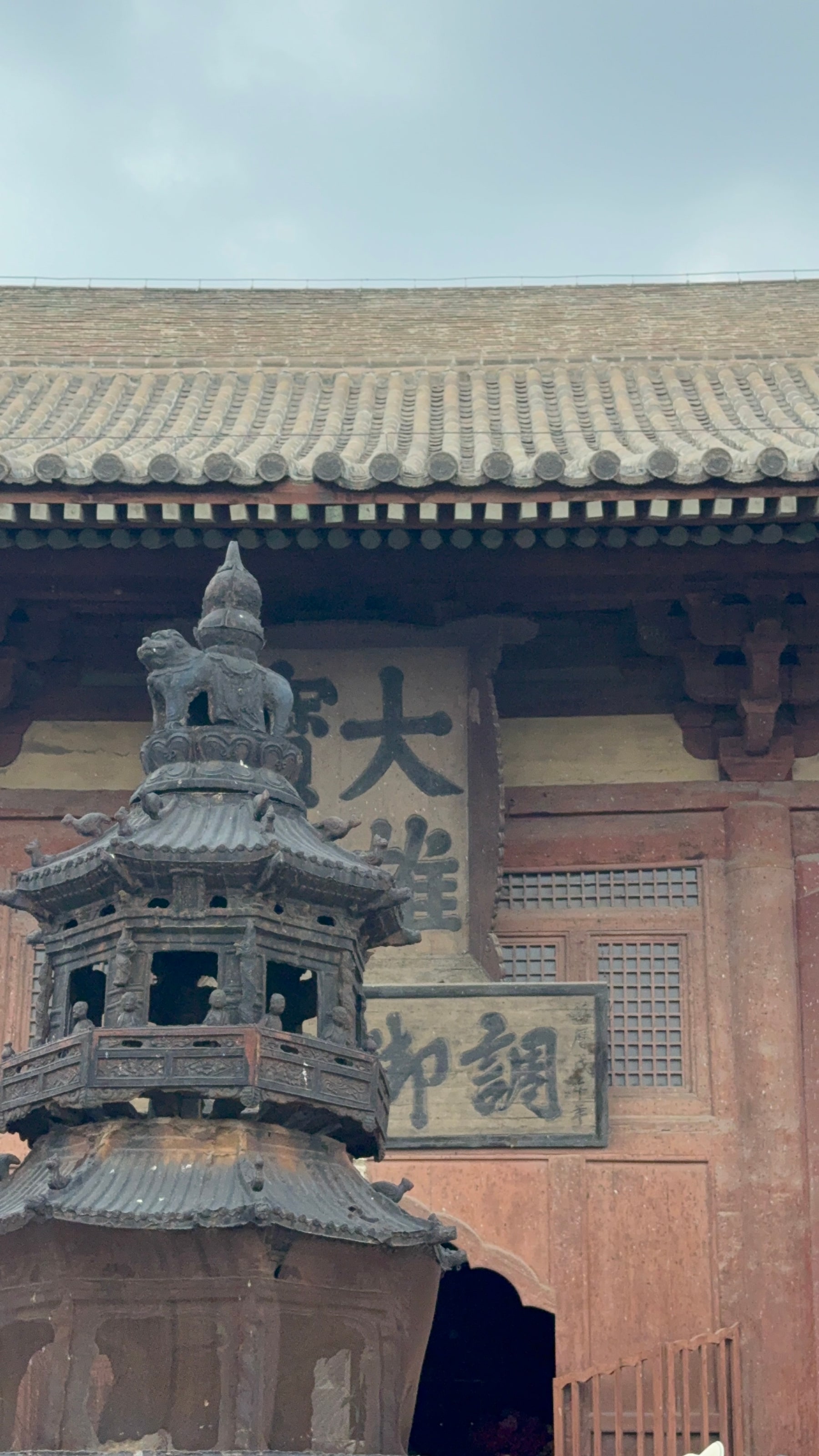 大殿前的铁香炉，把匾额、屋檐和缭绕的香火收进同一个画框。
