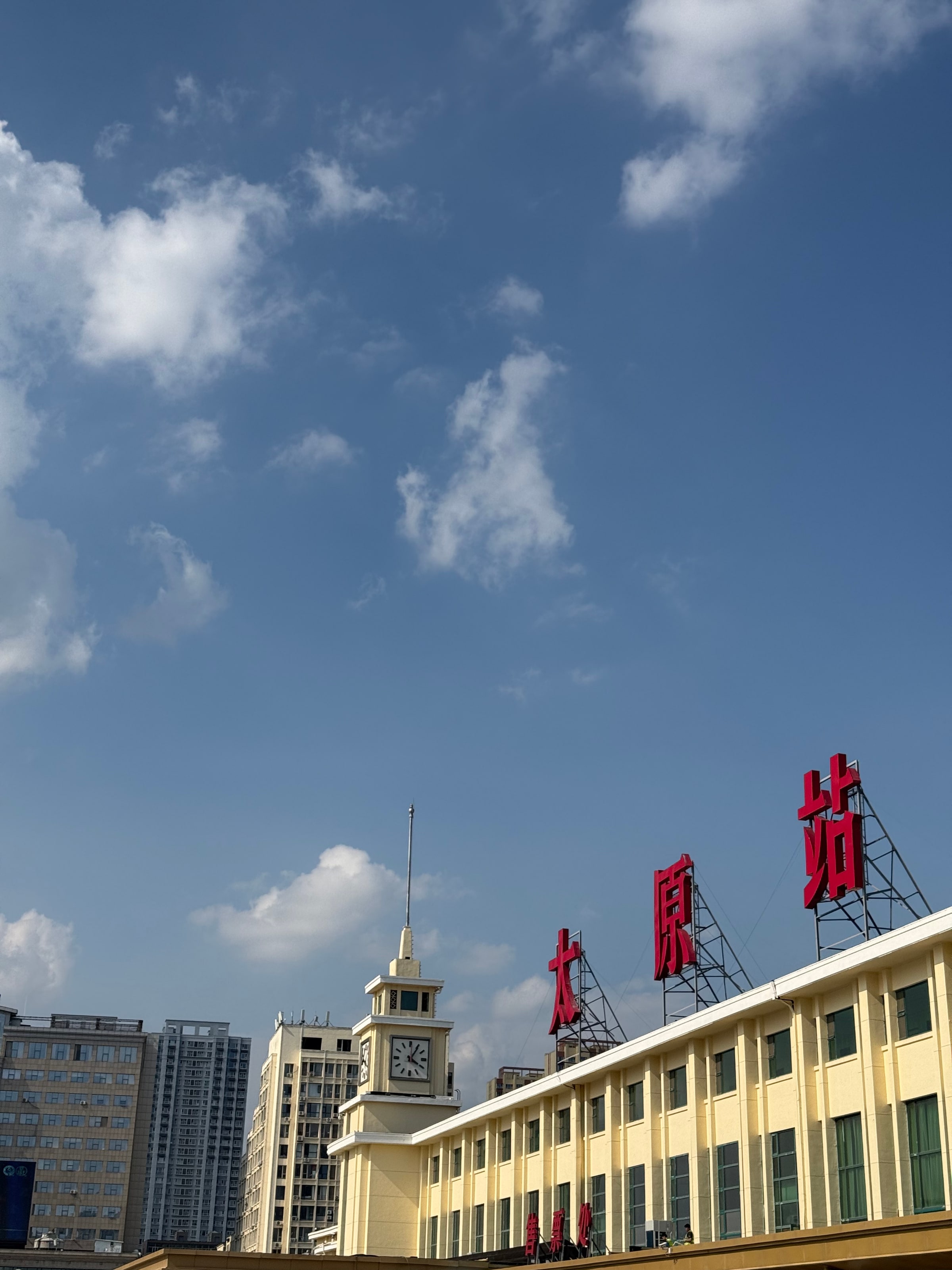 太原站前，红色的站名与钟楼在整点里格外醒目，人来人往都从它底下过。